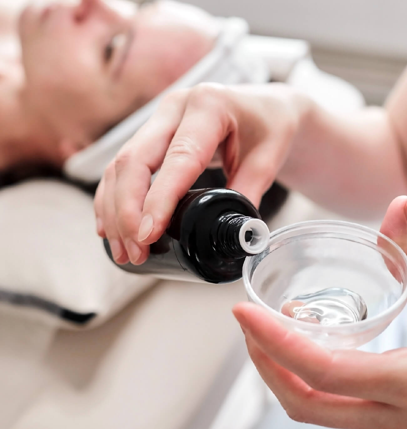 Préparation d’un peeling glycolique dans un bol en verre, mettant en avant une esthéticienne professionnelle versant le produit pour un soin exfoliant et éclaircissant du visage.
